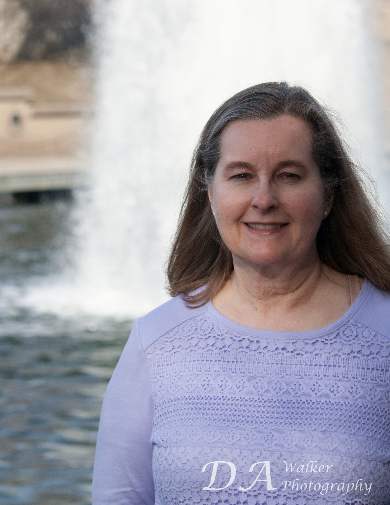 Woman standing in front of a fountain.